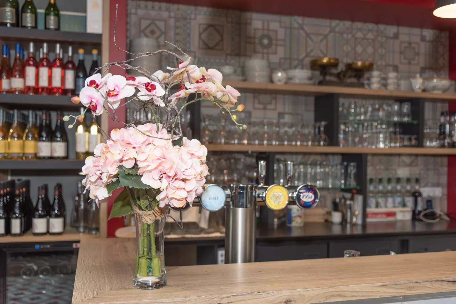 Focus sur le bar du restaurant Henriette avec fleur en décoration, détail raffiné